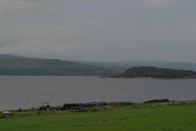 Tractor, hay, and loch. Must be the Highlands.