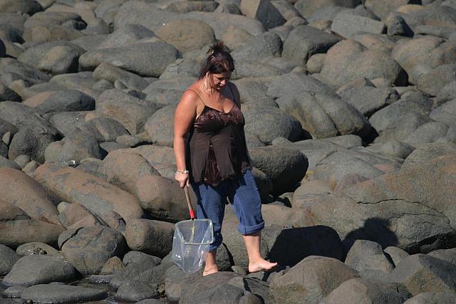Woman searching the beach. Looking for the same thing as the boy?